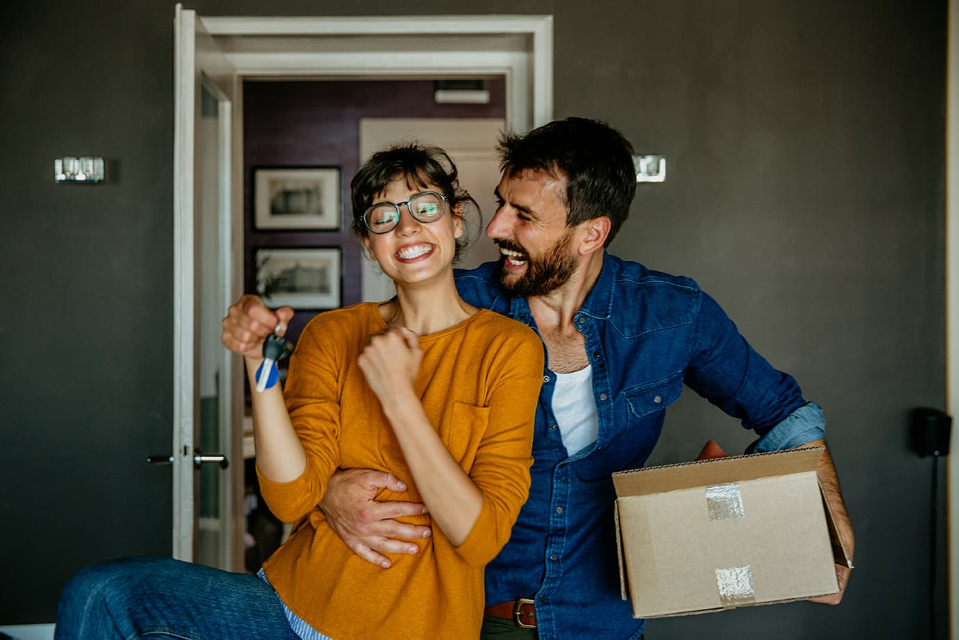 Excited couple holding a moving box